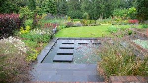 rectangular pond with floating stepping stones in landscaped gardens