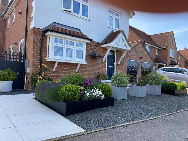 driveway and front garden with modern containers stuffed with plants
