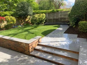 pretty garden with retaining wall in the foreground leading to lawns and planting