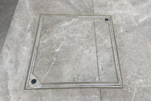 recessed manhole cover cleverly made to match porcelain patio