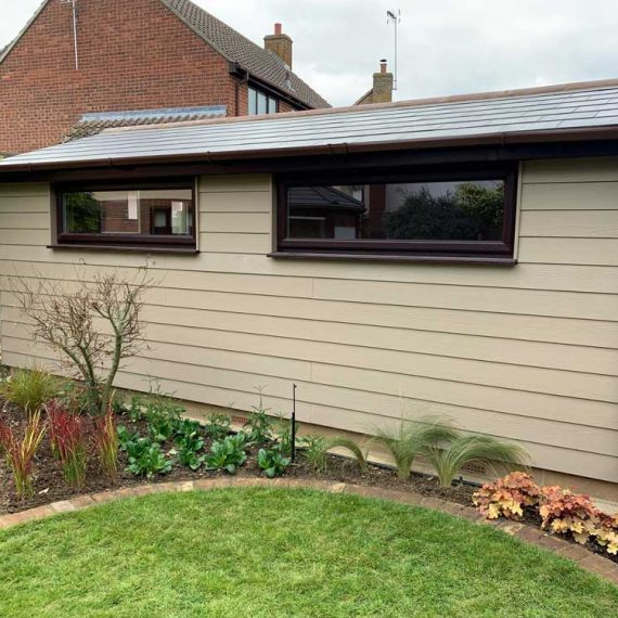 large garden workshop with cream painted shiplap cladding