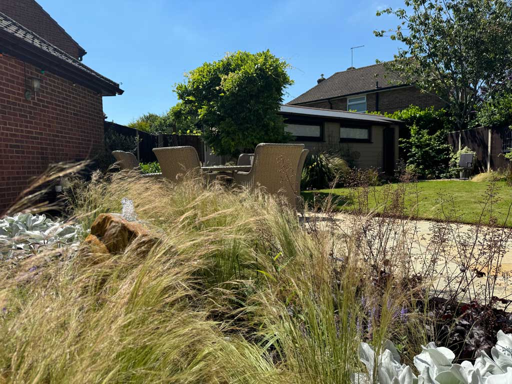 award winning garden with outdoor seating area, water feature and luxurious planting